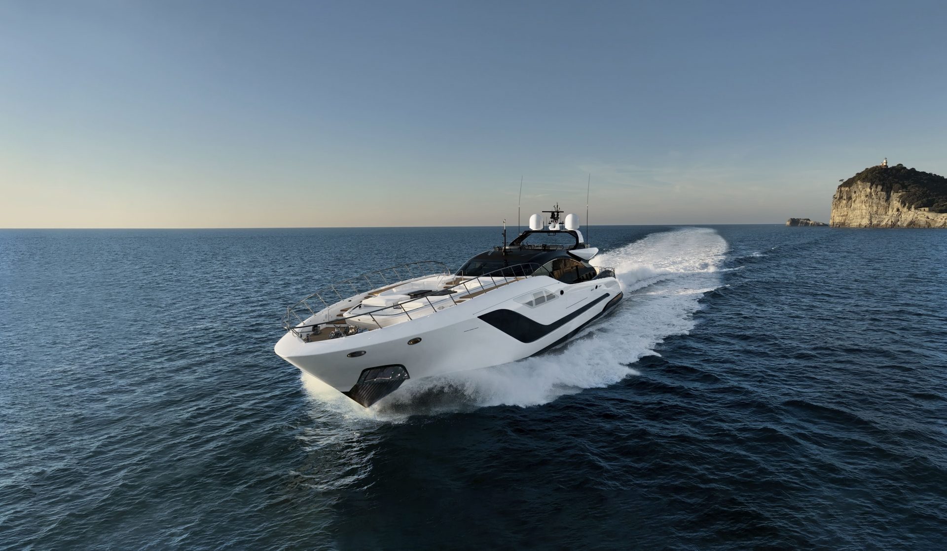 Mangusta yacht cruising near rocky coastline