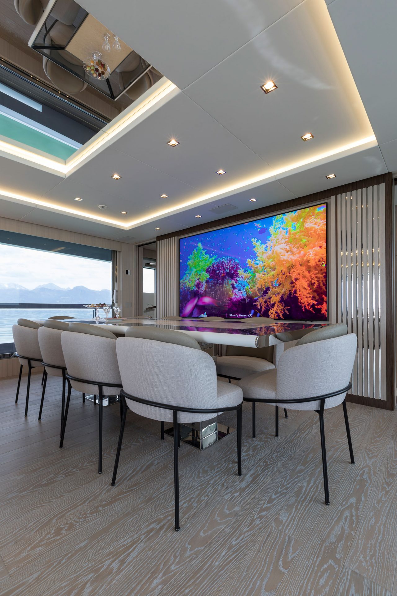 Sala da pranzo elegante con parete TV a tema marino.