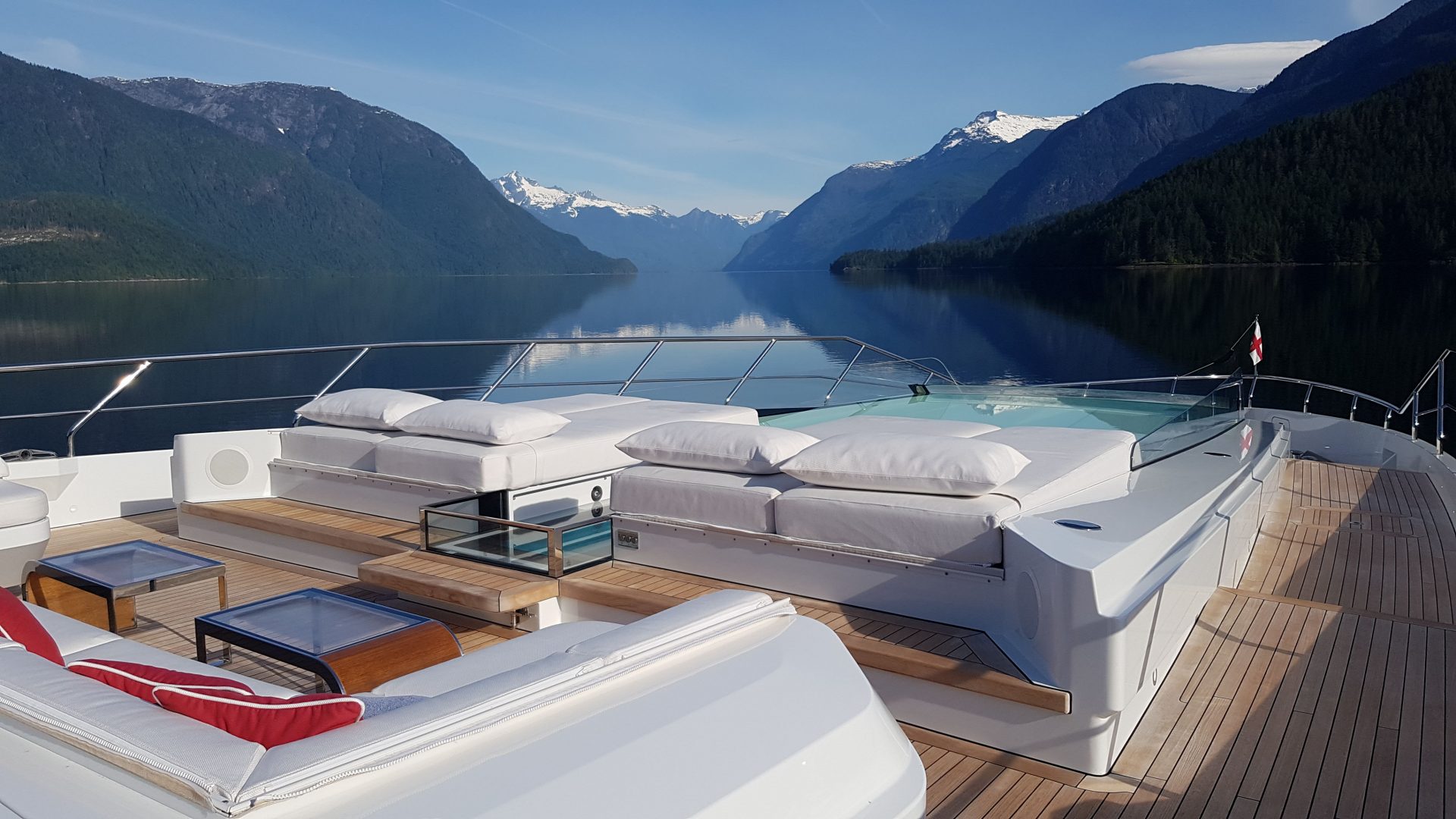 Yacht Mangusta con area relax e panorama alpino.