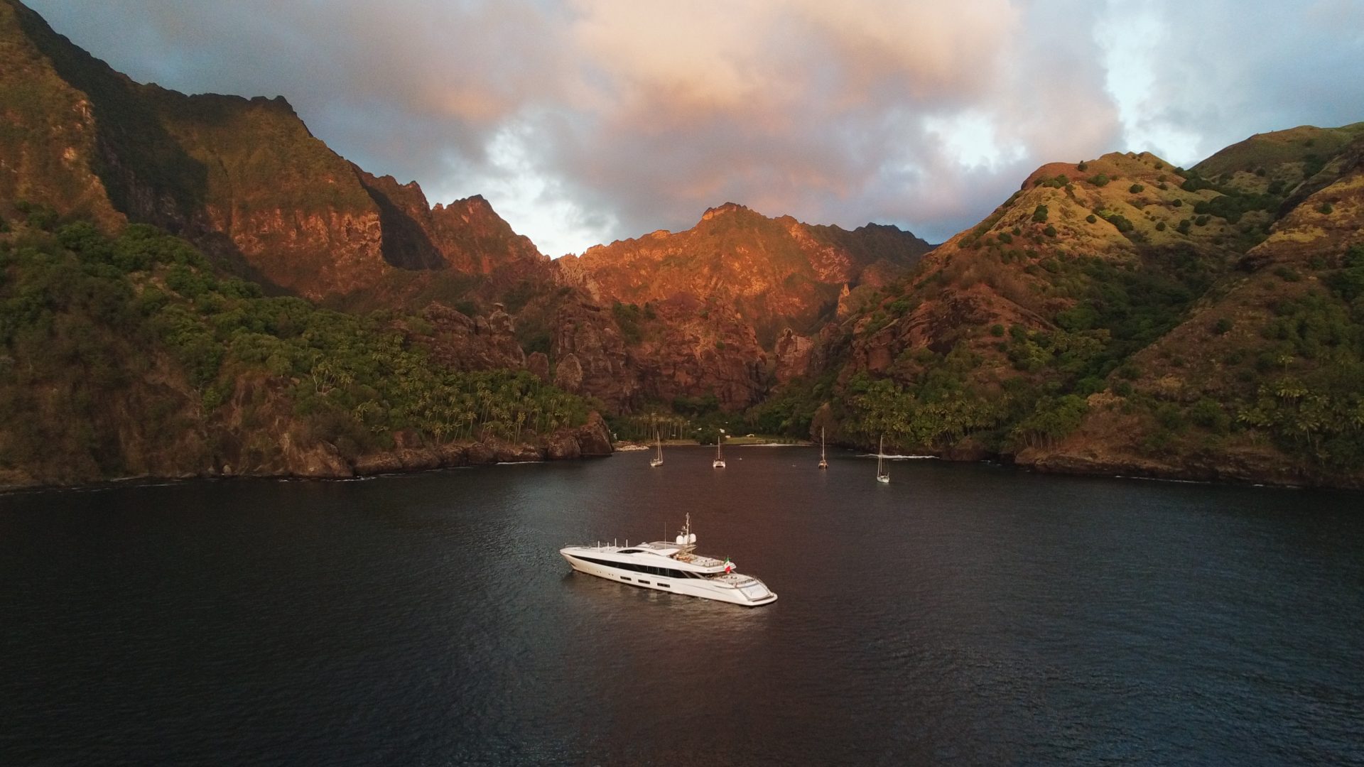 Yacht Mangusta al tramonto tra le montagne lussureggianti.