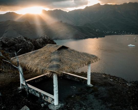 Tramonto su baia con yacht Mangusta in lontananza.