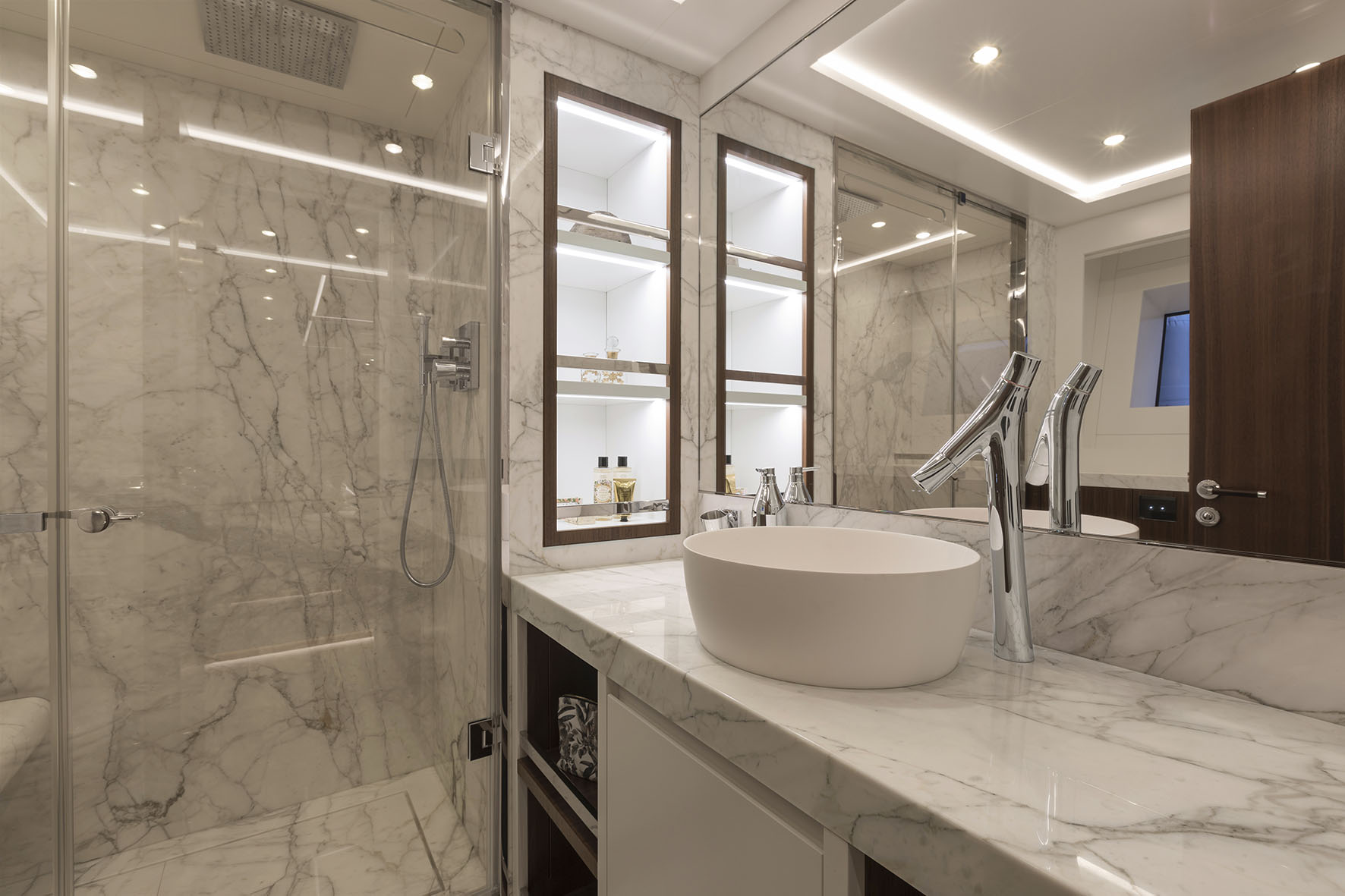 Bagno lussuoso con finiture in marmo e specchi illuminati.