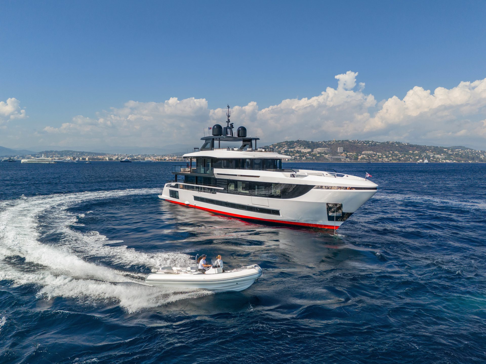 Mangusta yacht cruising with small tender nearby