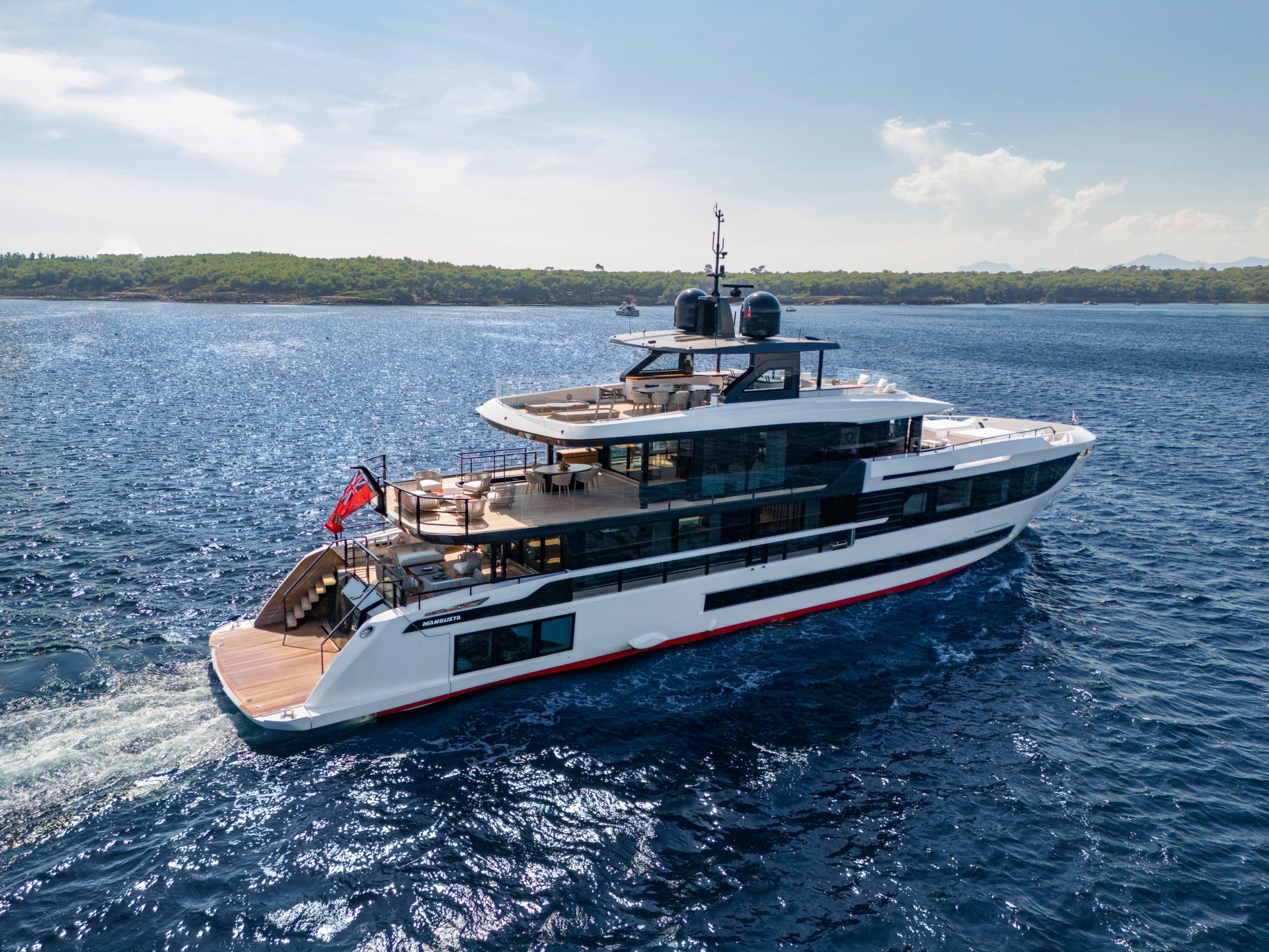 Luxurious Mangusta yacht cruising by the coast.