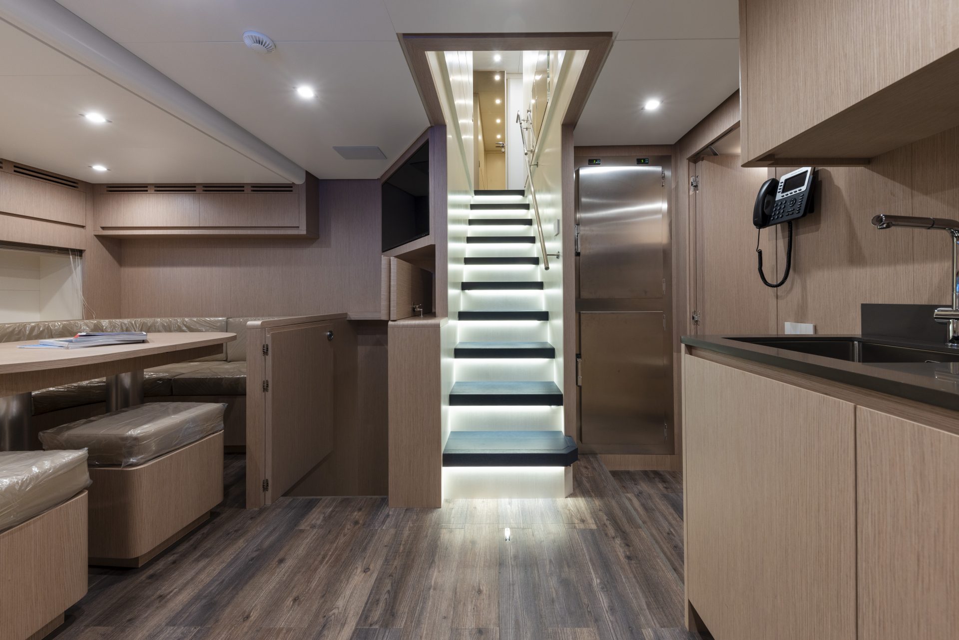 Sala interna moderna di yacht Mangusta con scala illuminata.