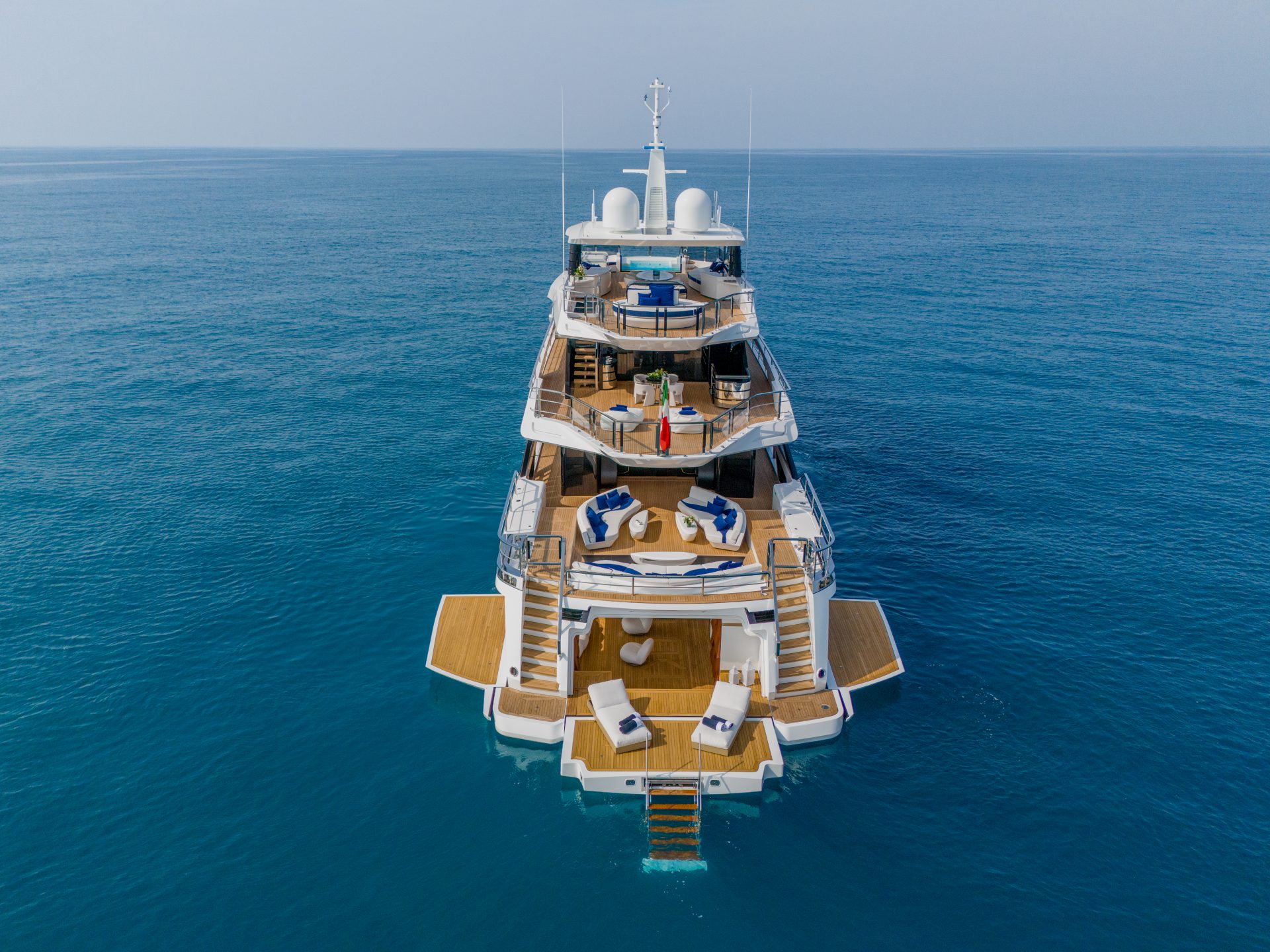 Yacht Mangusta su mare blu vibrante e cielo limpido.
