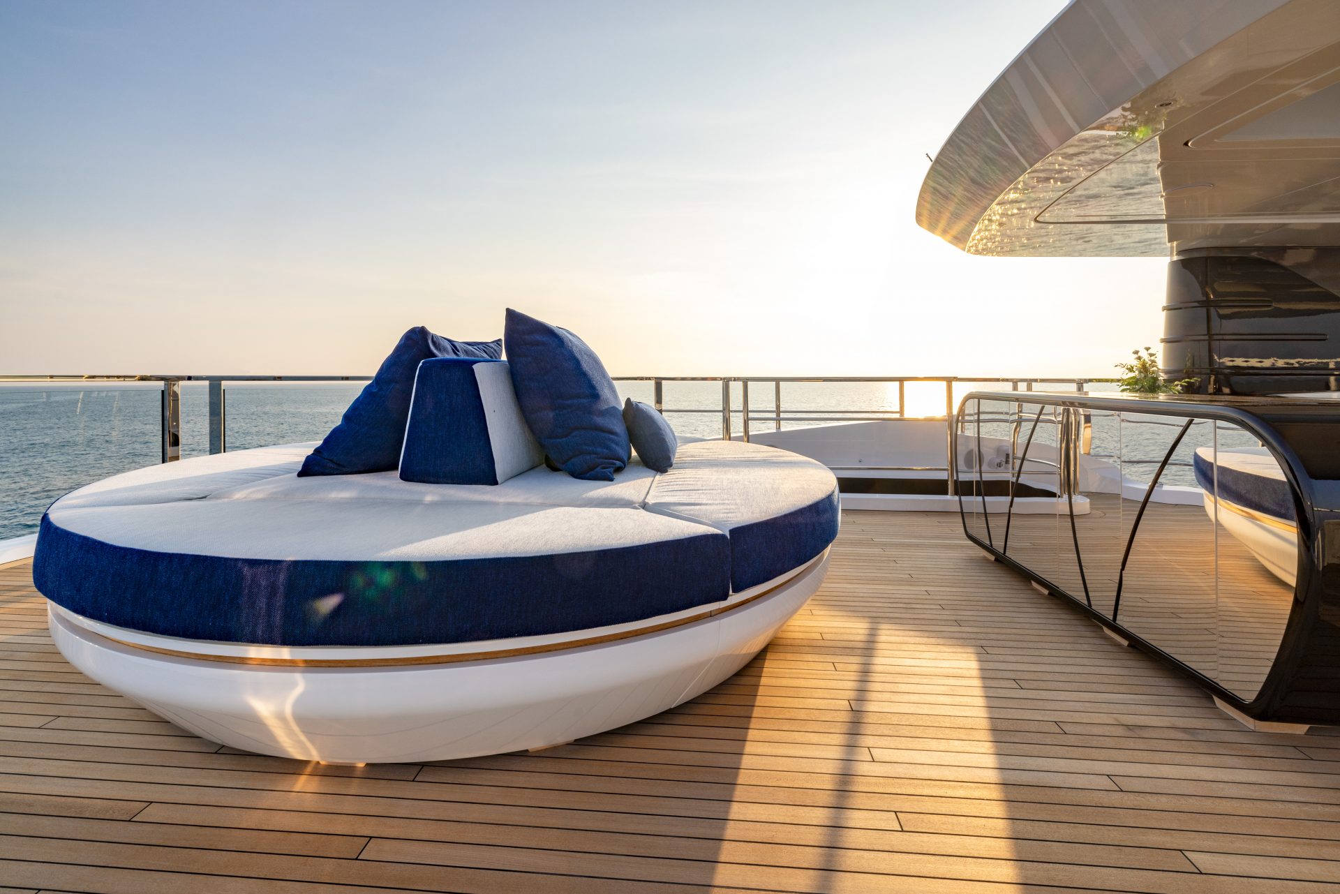 Sundeck lussuoso con lettino circolare e cuscini blu.