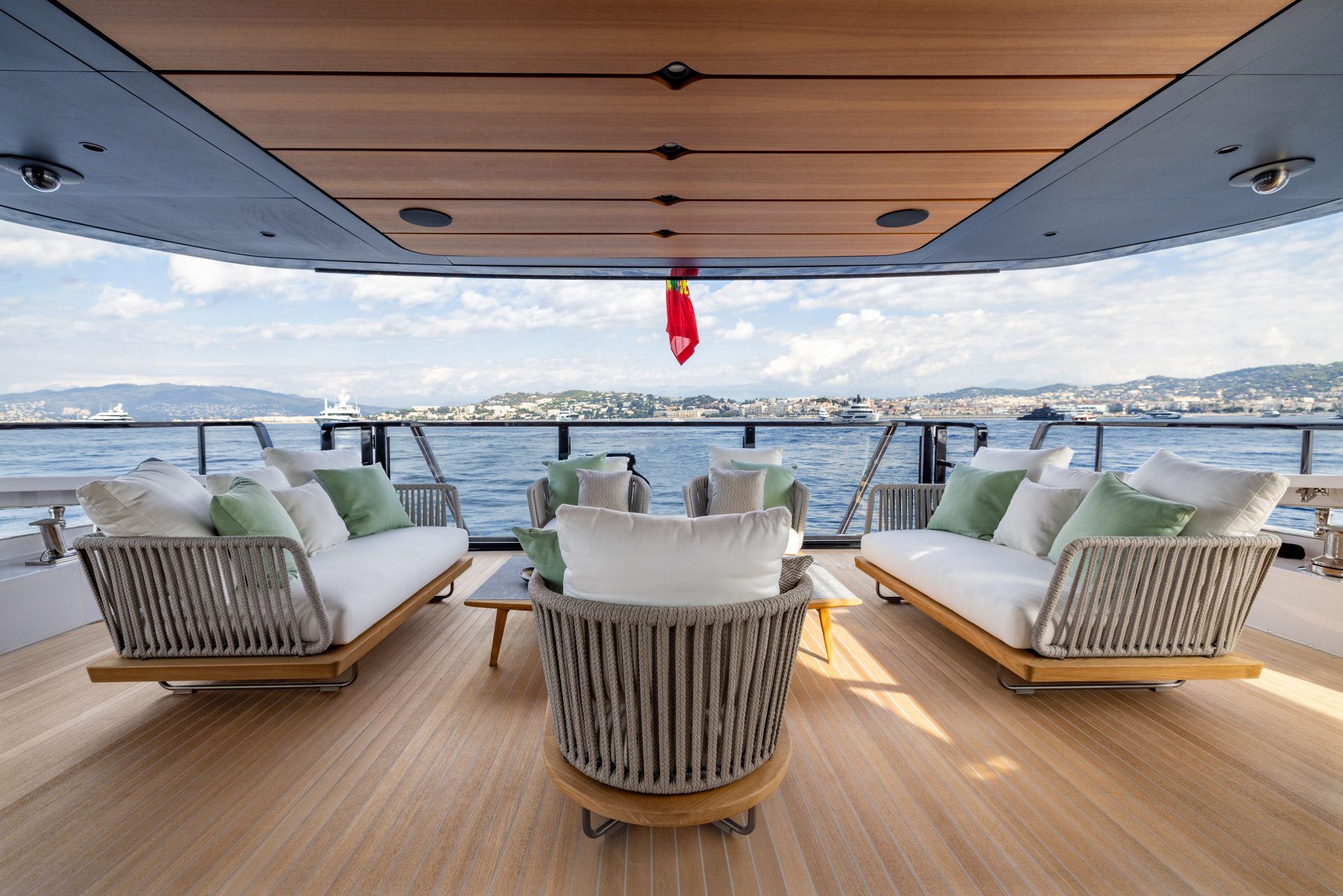 Luxury yacht deck with ocean view and cushioned seats.