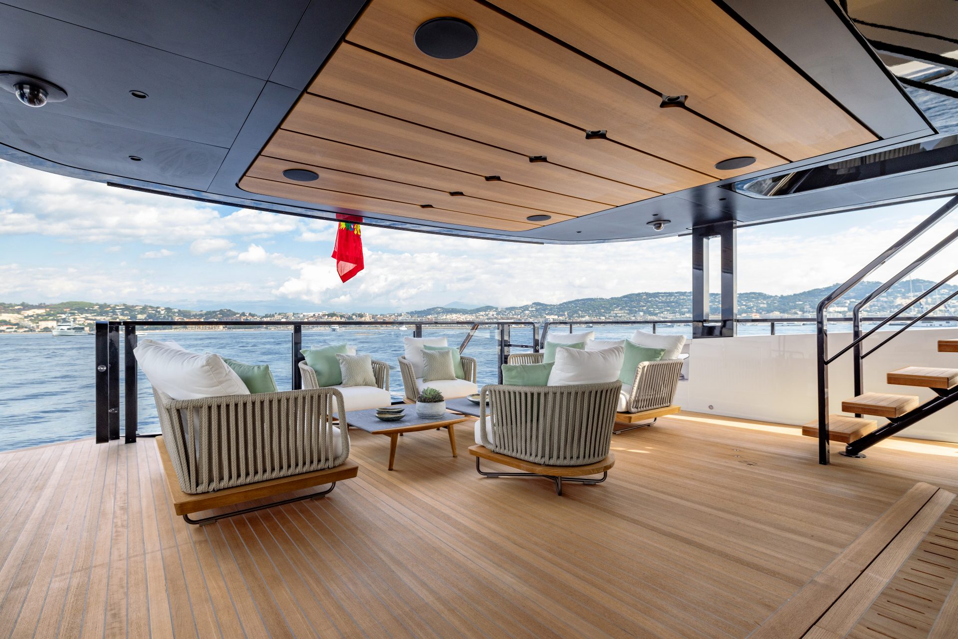 Cozy lounge on Mangusta yacht deck with sea view.
