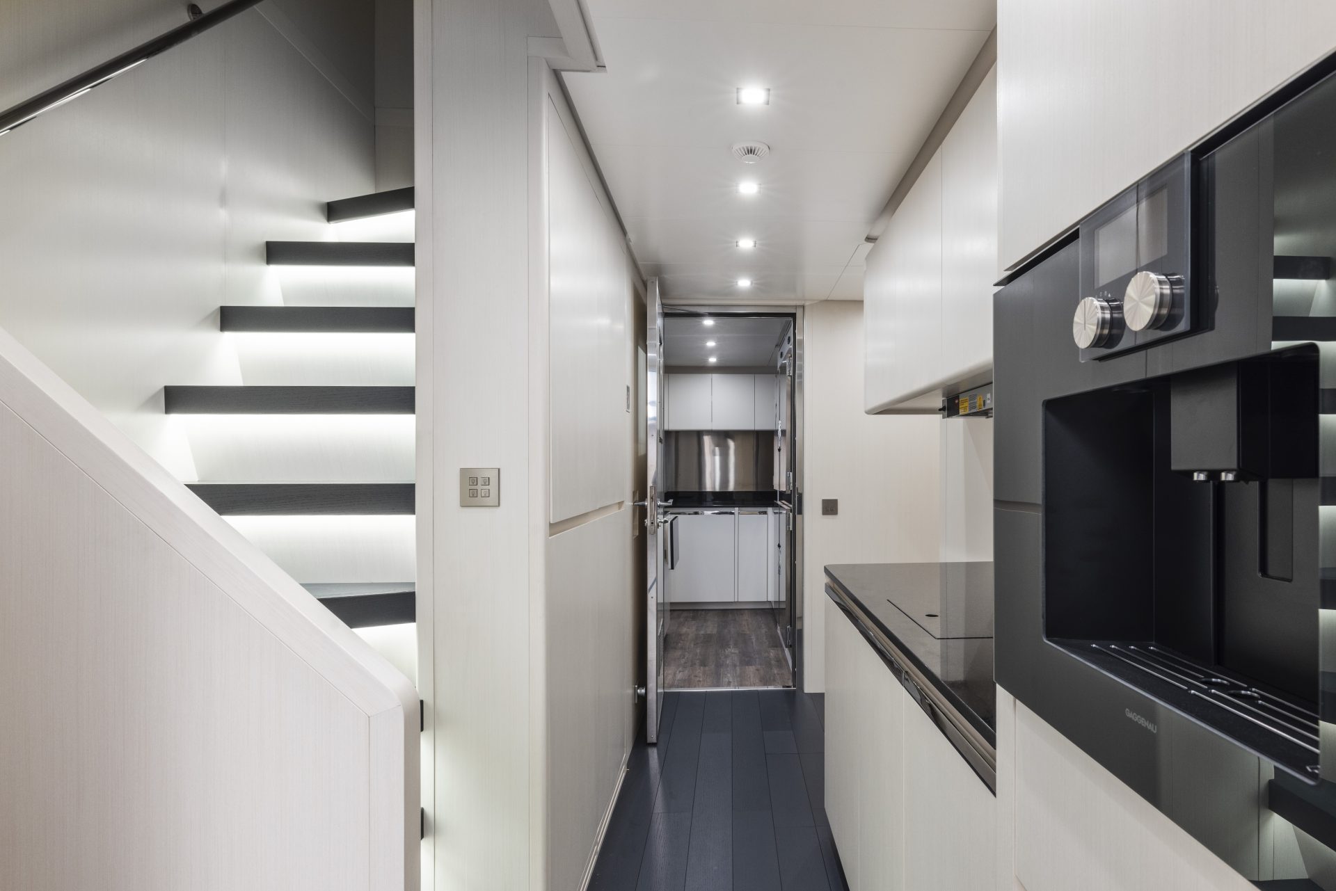 Scala illuminata e cucina moderna su yacht di lusso.