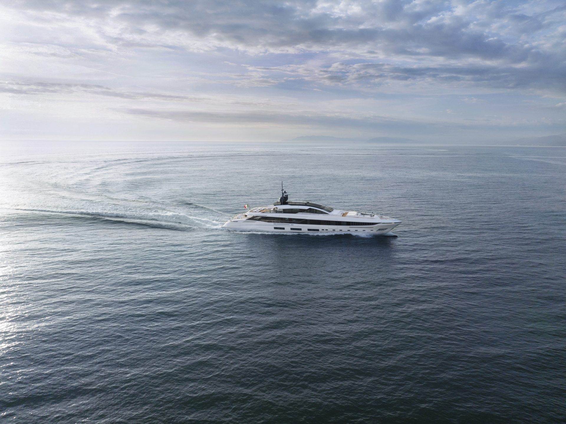 Yacht Mangusta naviga in mare aperto sotto cieli nuvolosi.