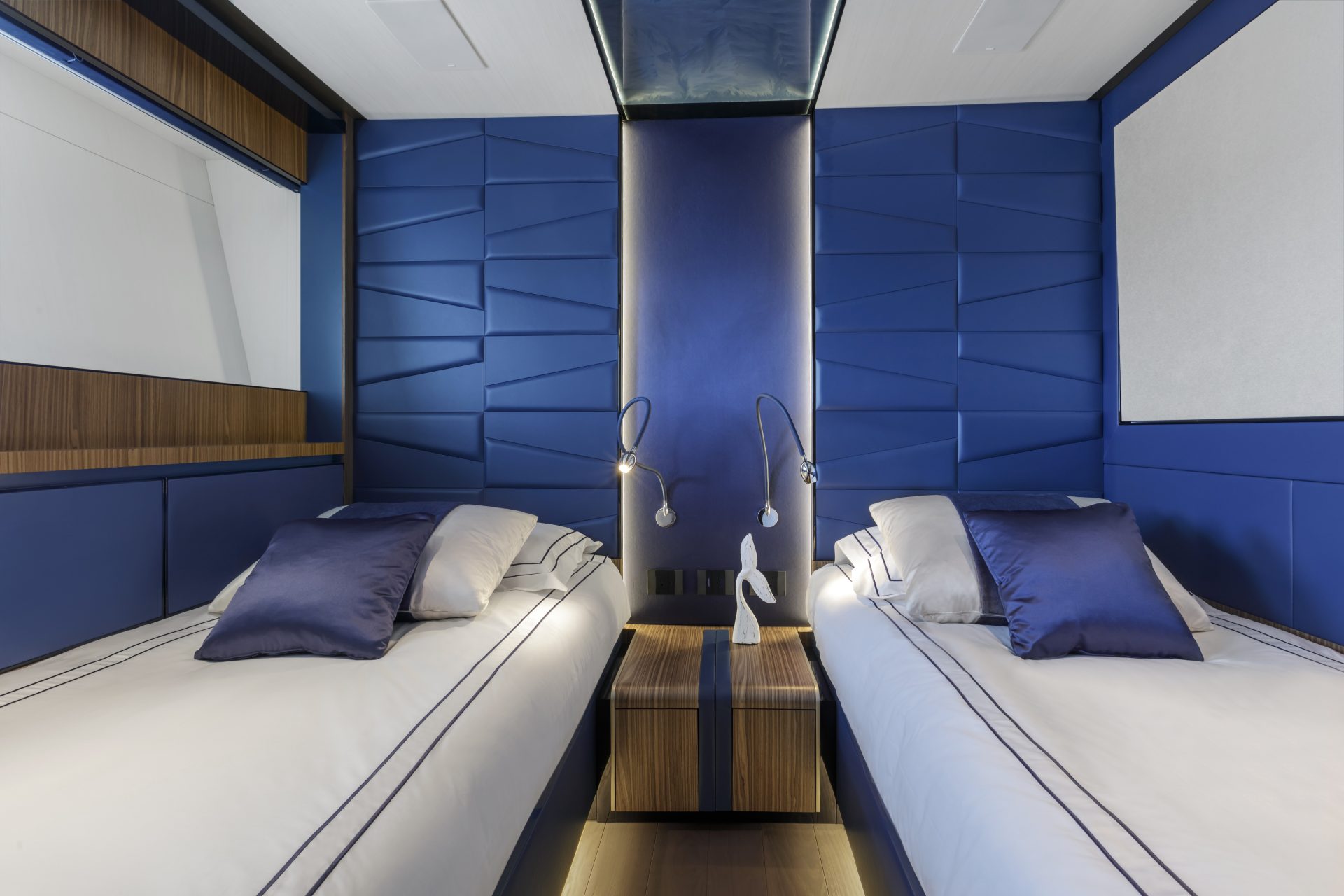 Cabina lussuosa con letti gemelli blu.