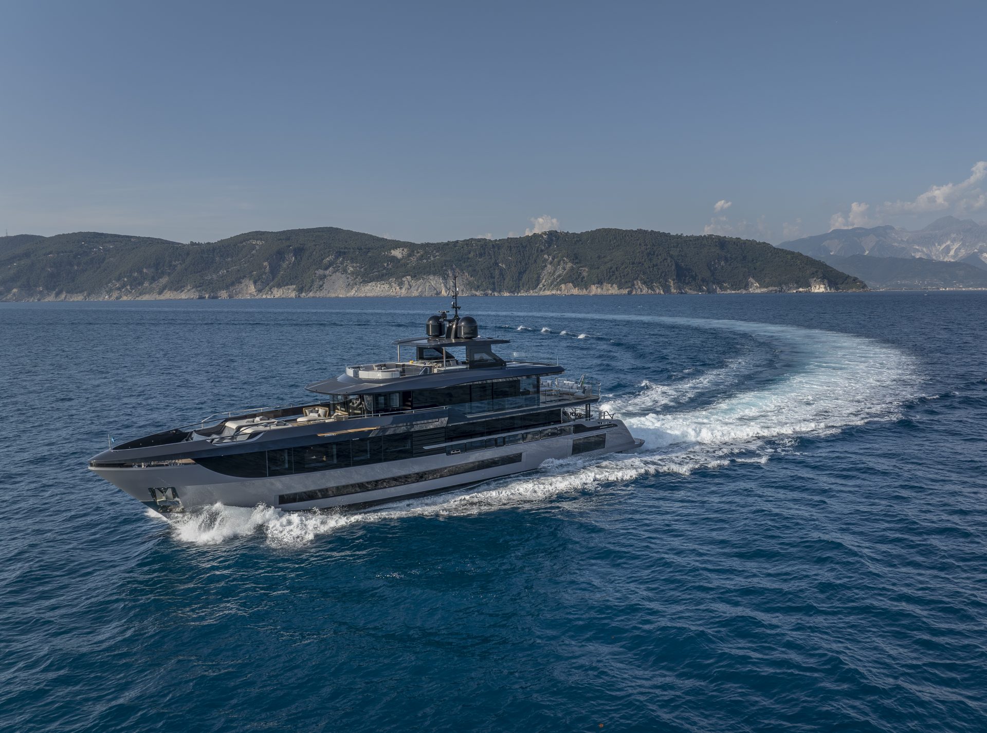 Mangusta yacht cruising near scenic coastline