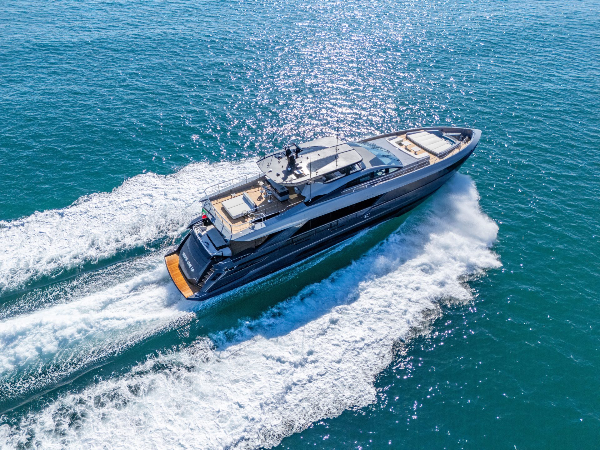 Yacht Mangusta naviga sull'oceano con scia bianca.