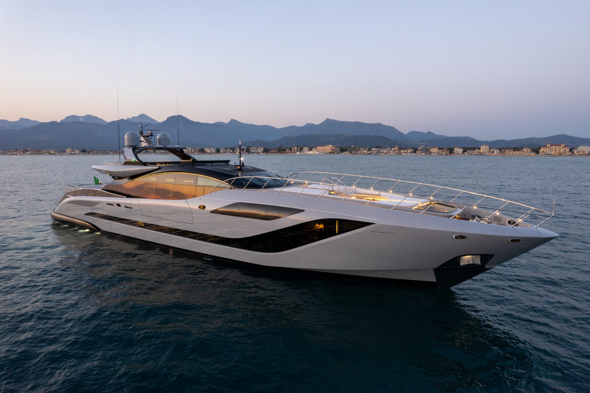 Mangusta yacht cruising at dusk near coastline