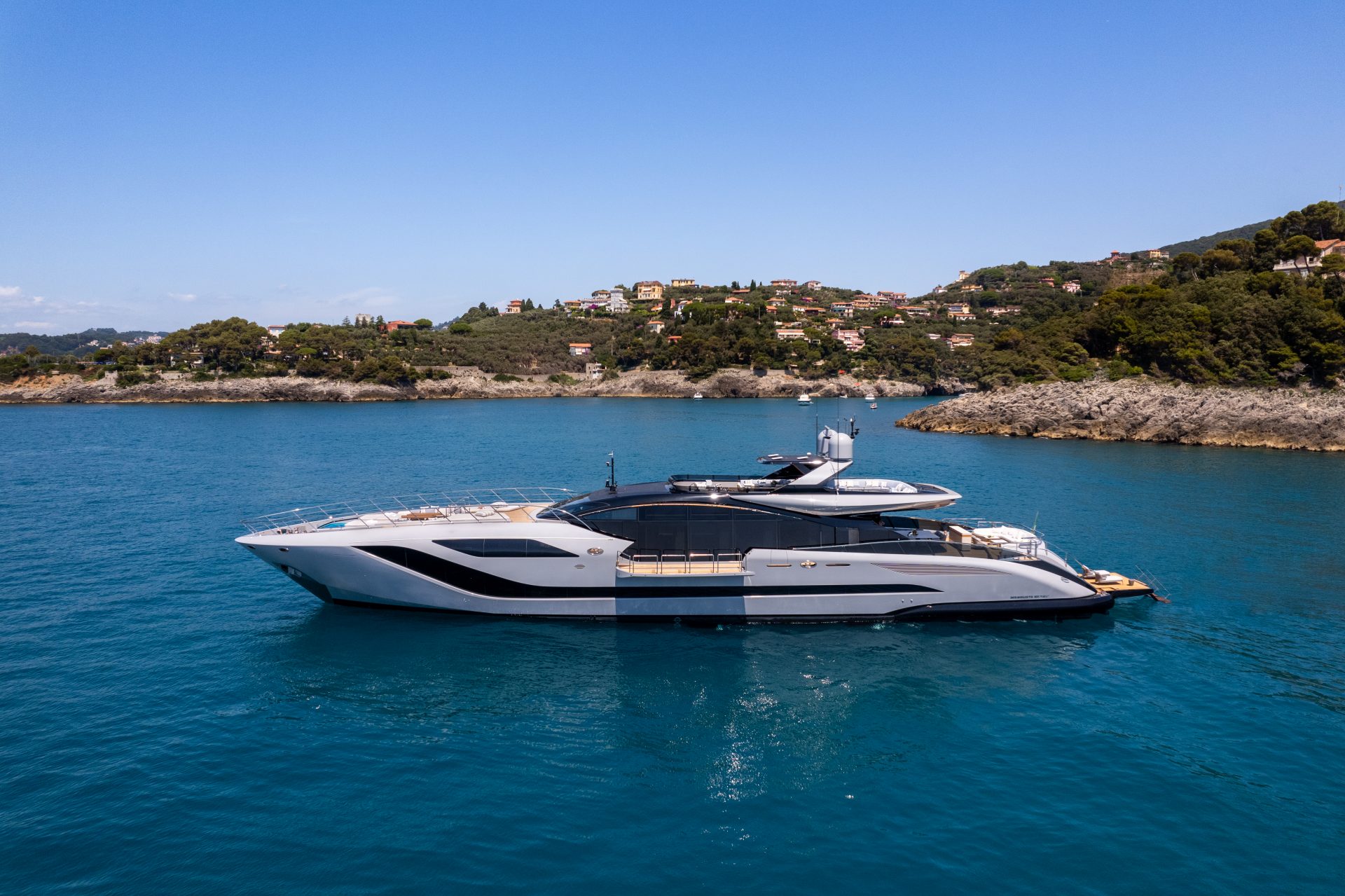 Mangusta yacht cruising near scenic coastline.