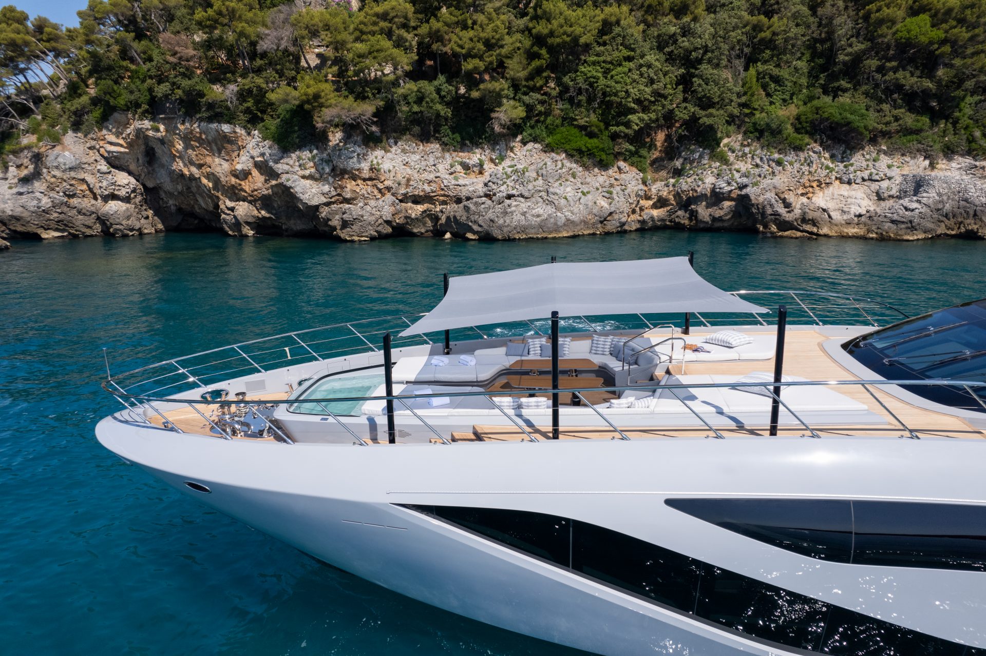 Luxurious Mangusta yacht with sunshade and lounge.