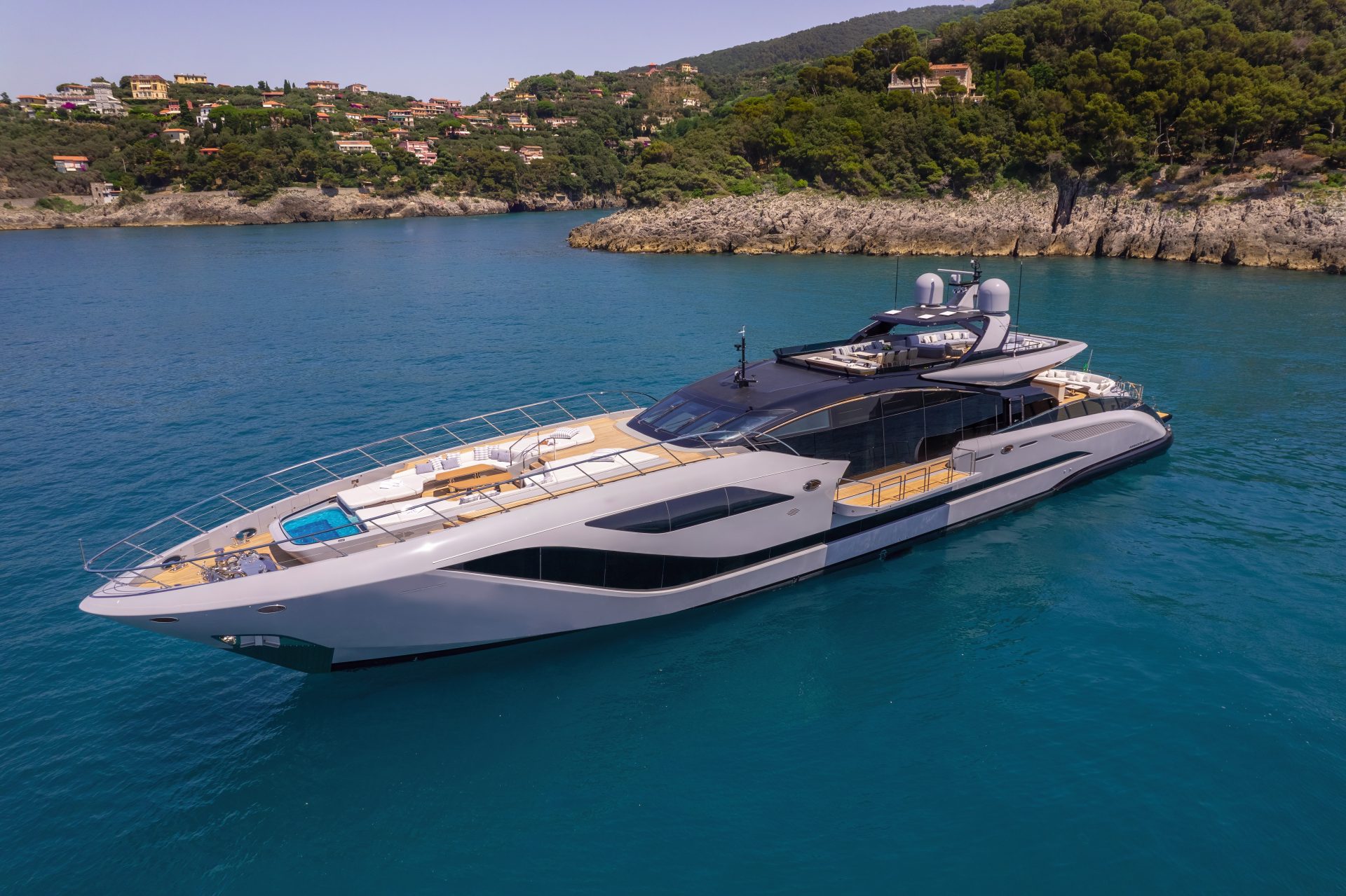 Mangusta yacht cruising near scenic coastline.