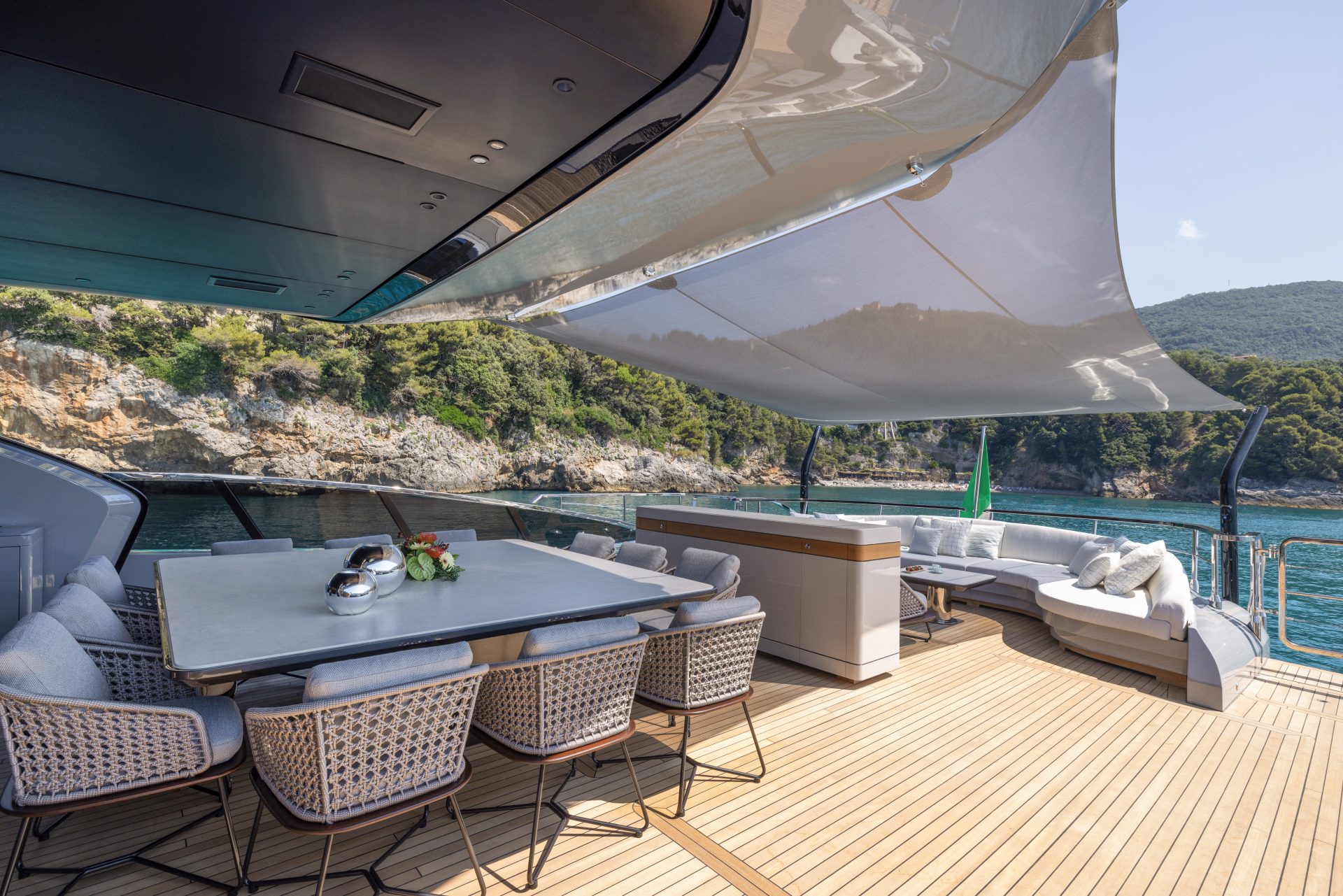 Luxury yacht deck with dining area and ocean view.