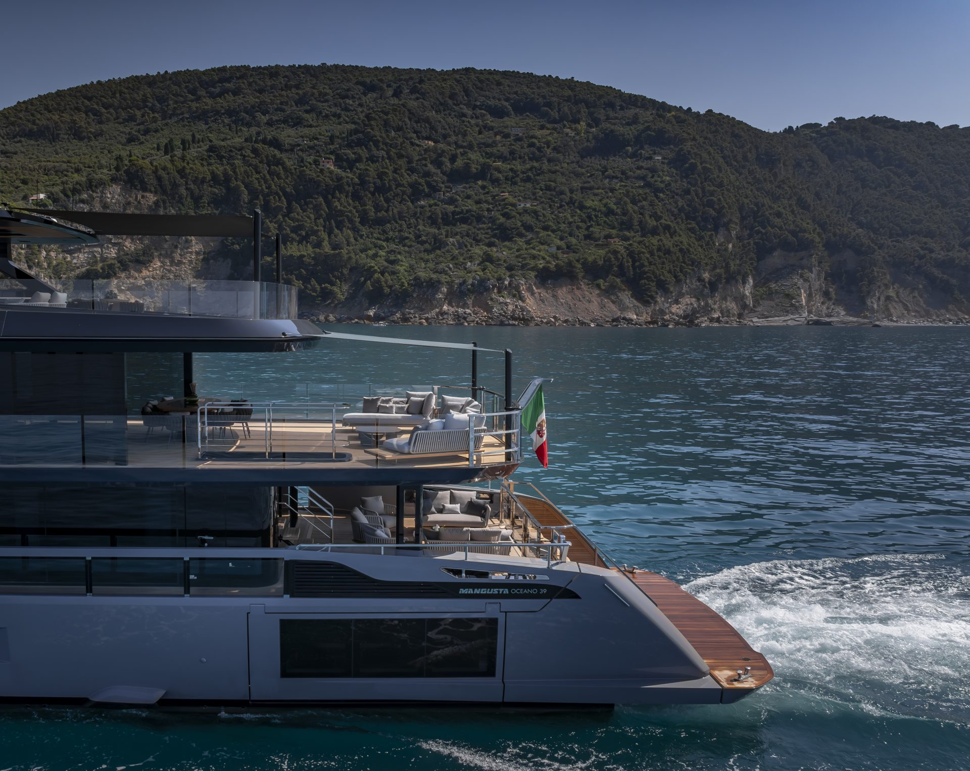 Mangusta yacht cruising by scenic coastline