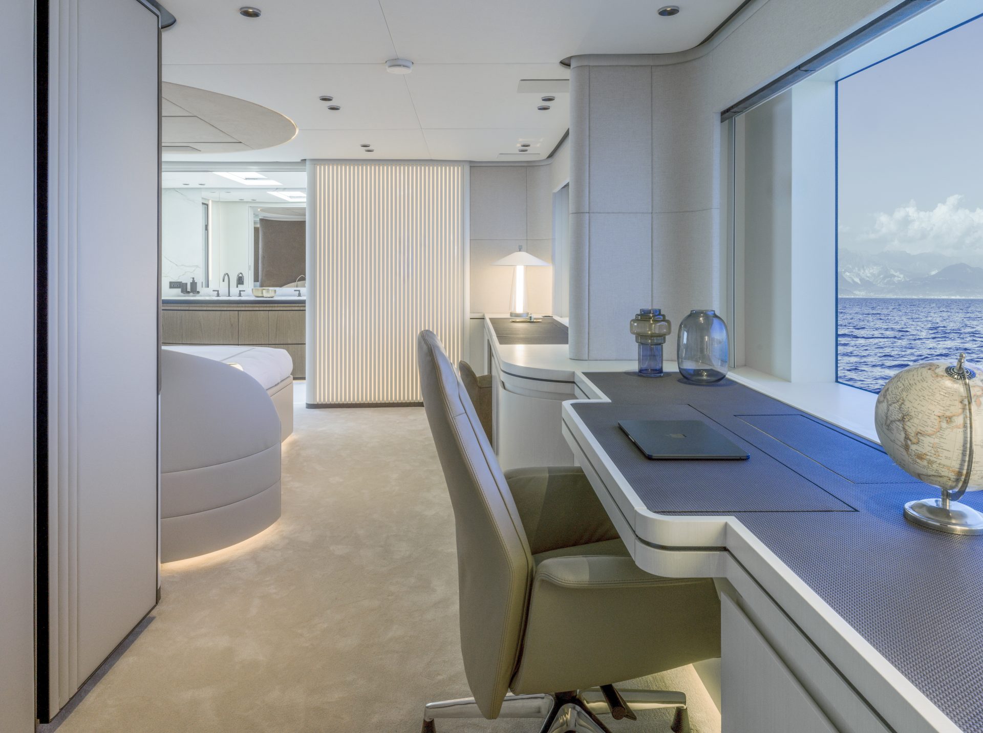 Luxury yacht cabin with ocean view and desk.
