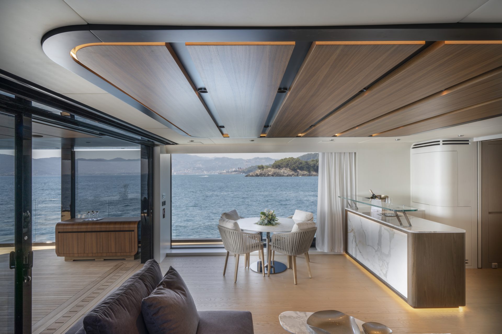 Luxury yacht interior with ocean view dining area.