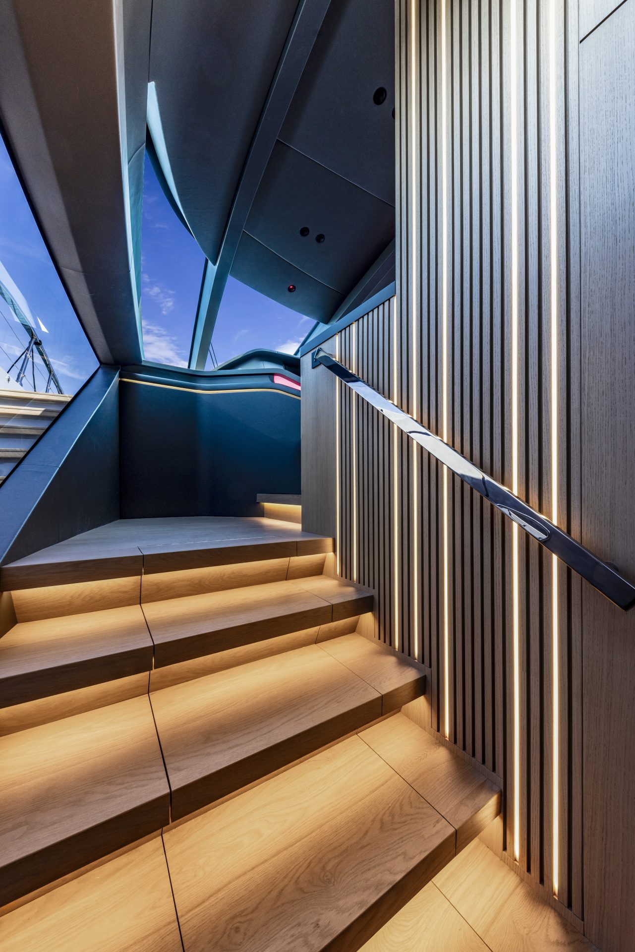 Sleek yacht staircase with elegant lighting design.