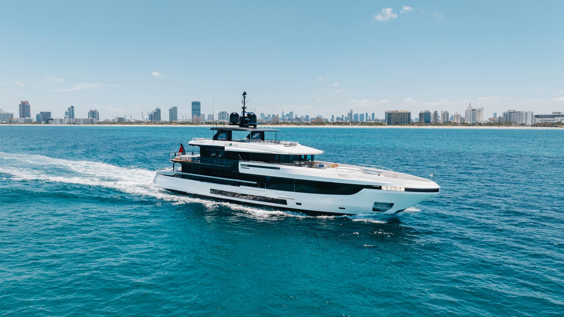 Mangusta yacht cruising near city skyline