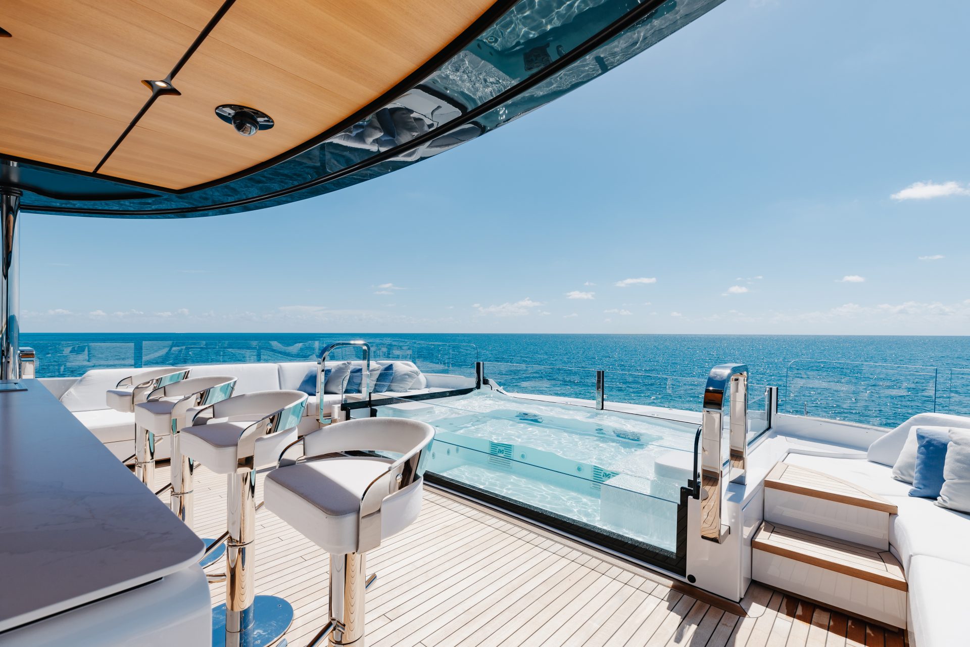 Luxury yacht deck with hot tub and ocean view.