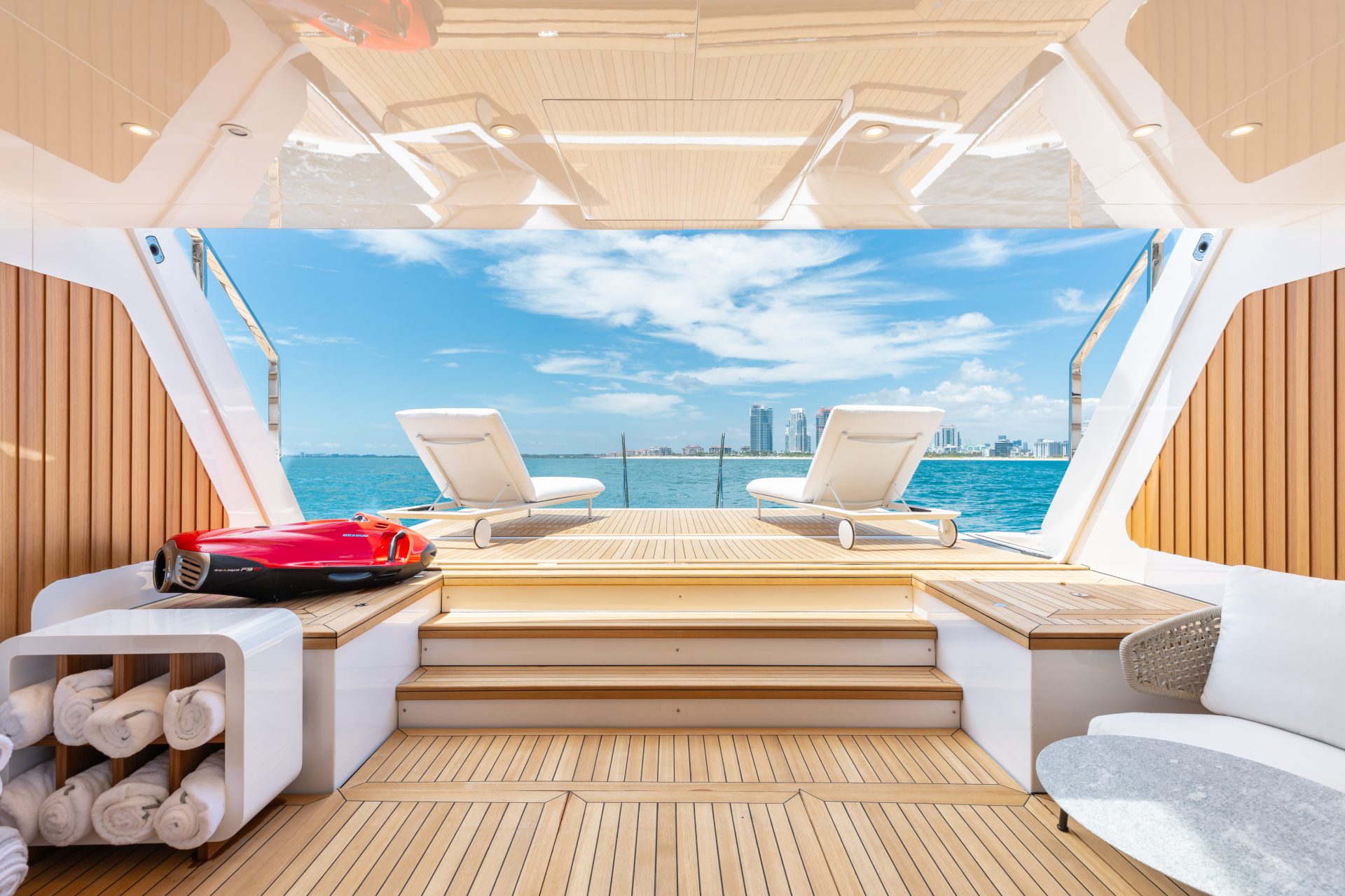 Luxury yacht deck with ocean view and sun loungers.