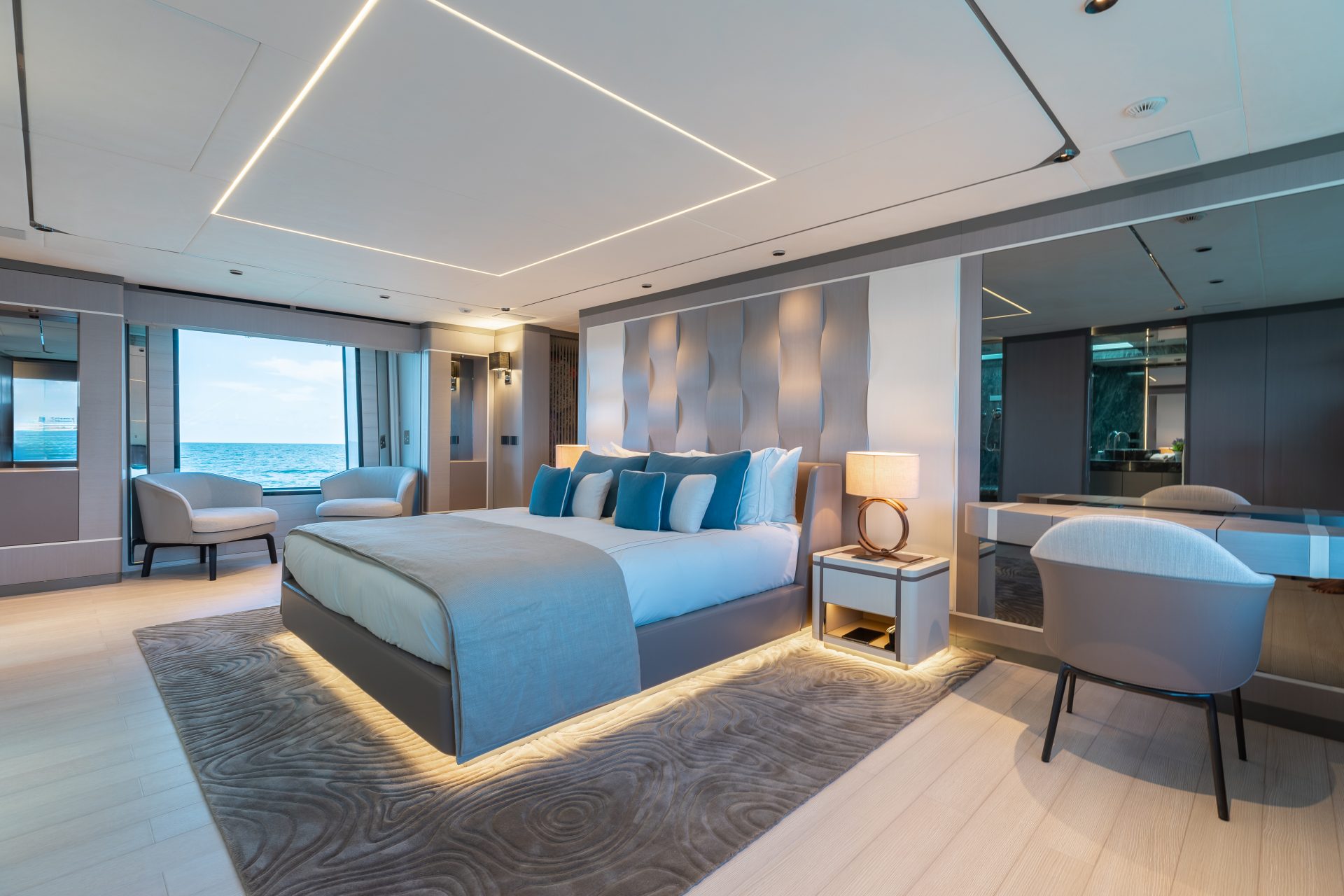 Luxury yacht bedroom with ocean view and modern decor.