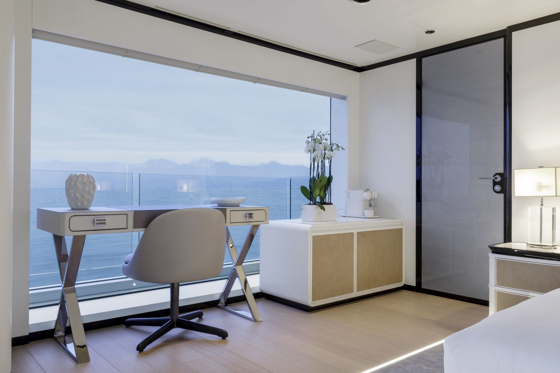 Interni di lusso su Mangusta Yachts, vista oceano, scrivania elegante con sedia moderna, dettagli raffinati e arredamento contemporaneo.