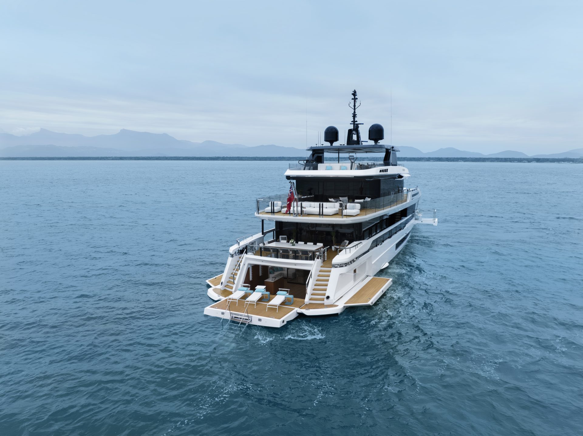 Yacht Mangusta naviga in mare aperto con vista monti.