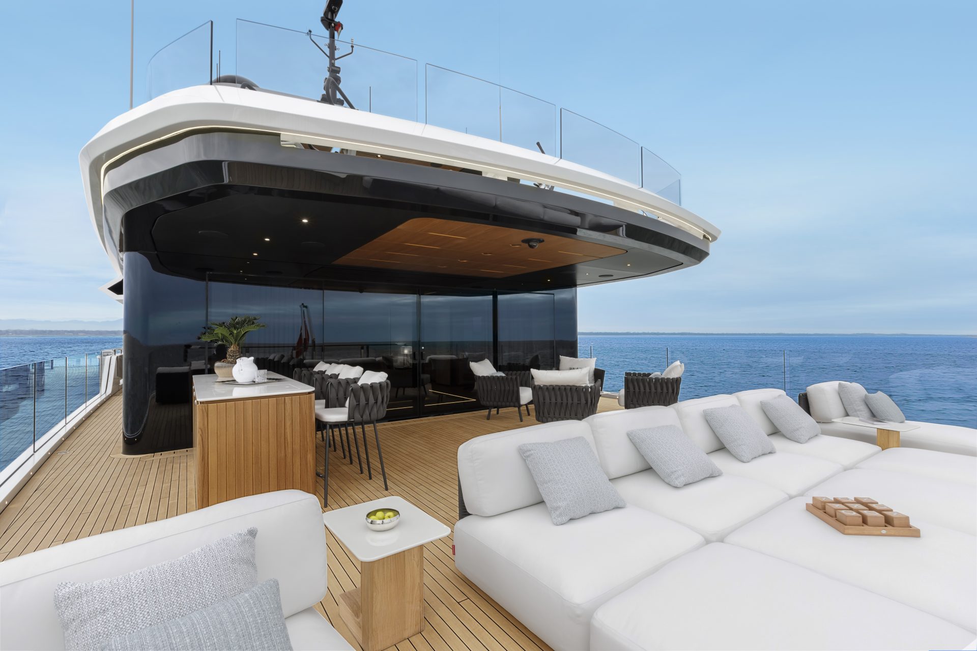 Sundeck lussuoso con divani e vista mare su Mangusta Yachts.