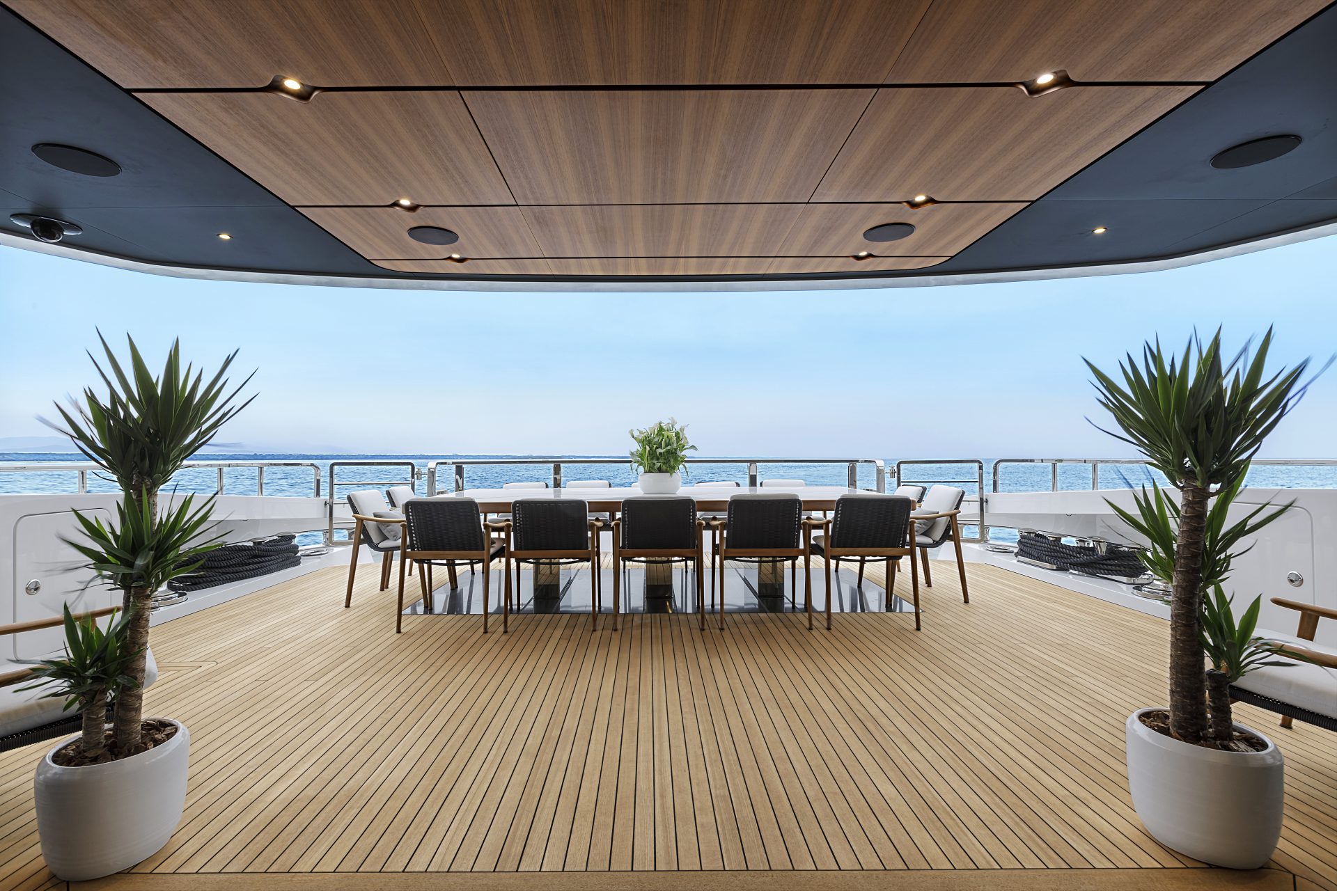 Ponte di poppa Mangusta Yachts con tavolo e sedie eleganti.