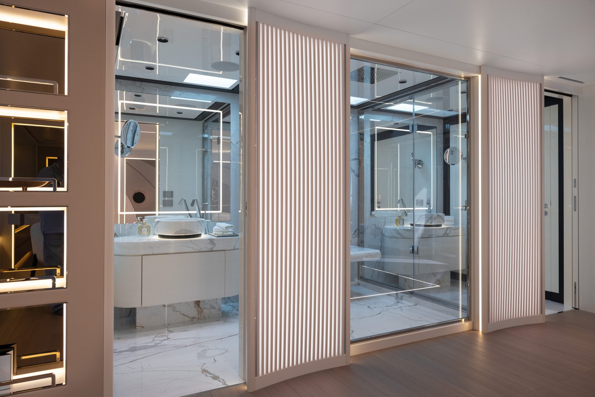 Elegante bagno in marmo con lavandino moderno su yacht Mangusta, riflessi LED e design contemporaneo.